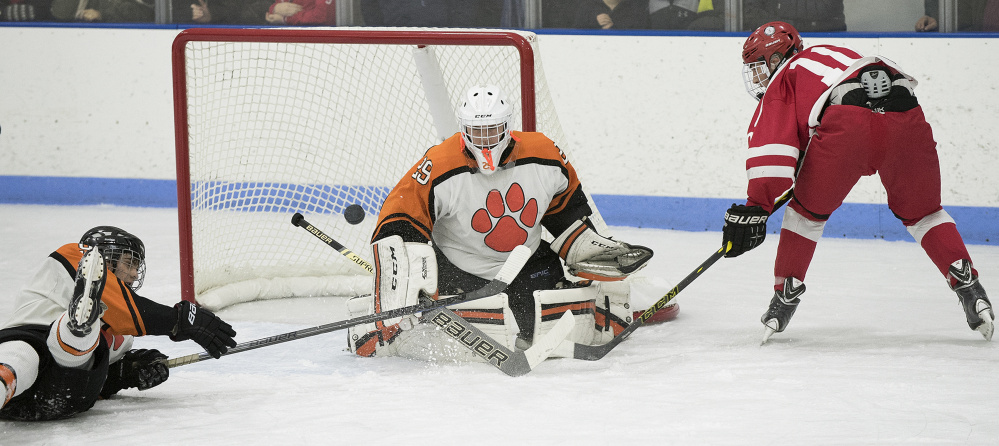 Gardiner goalie Michael Poirier gets in position to stop a shot by Cony forward Riley Boivin during a game at the Ice Vault earlier this season.