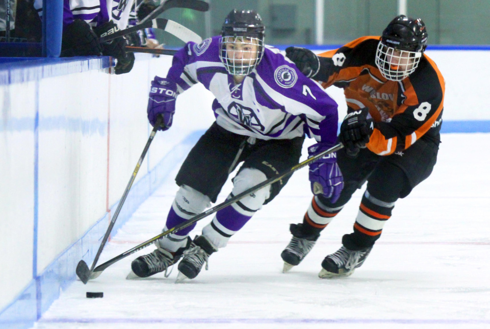 Waterville forward Nick Denis skates by Winslow Thomas Tibbetts during a game at Colby College this season.