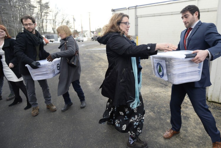 David Boyer, manager of the Campaign to Regulate Marijuana Like Alcohol, passes a box of petitions to Rep. Diane Russell as they prepare for a trip to Augusta to submit them to the Secretary of State’s Office in February.