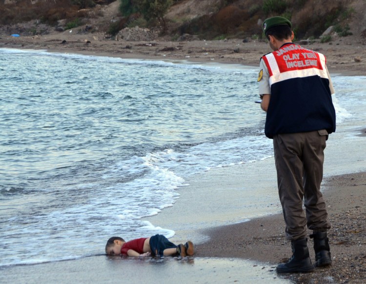 Sept. 2, 2015: A paramilitary police officer investigates the scene before carrying the body of 3-year-old Aylan Kurdi from the sea, near the beach resort of Bodrum, Turkey. 
