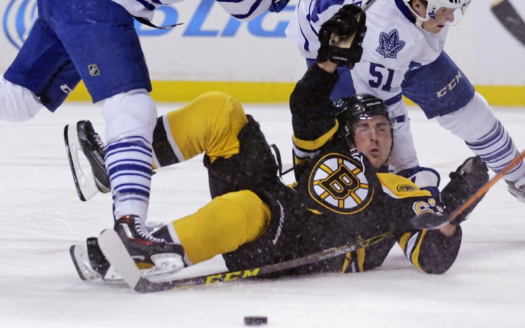 Bruins left wing Brad Marchand gets dropped to the ice in front of Maple Leafs goalie James Reimer on a check in the second period of Tuesday night’s loss in Boston.