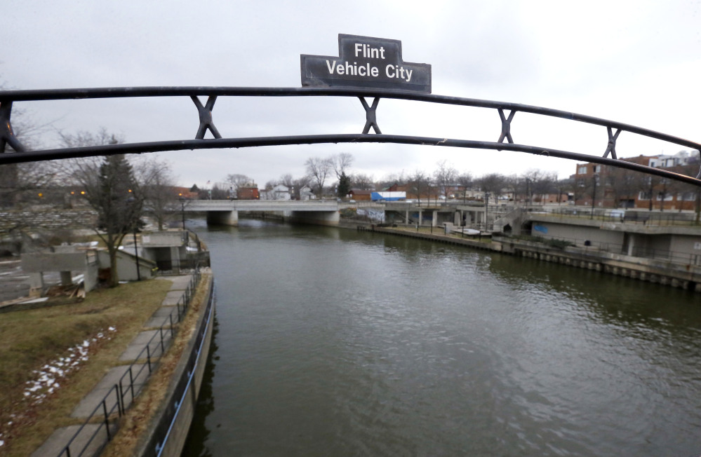 FILE - This Jan. 26, 2016 file photo shows a sign over the Flint River noting Flint, Mich., as Vehicle City. When Michigan Gov. Rick Snyder disclosed a spike in Legionnaires’ cases on Jan. 13, 2016, he said he had learned about it just a couple days earlier. Internal emails however show high-ranking officials in Snyder’s administration were aware of a surge in Legionnaires’ disease potentially linked to Flint’s water long before the governor reported the increase to the public last month. (AP Photo/Carlos Osorio, File)