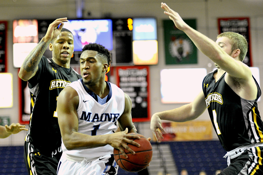 UMaine’s Aaron Calixte drives the lane against UMBC’s Jairus Lyles and Joel Wincowski in the first half Saturday at the Portland Expo.