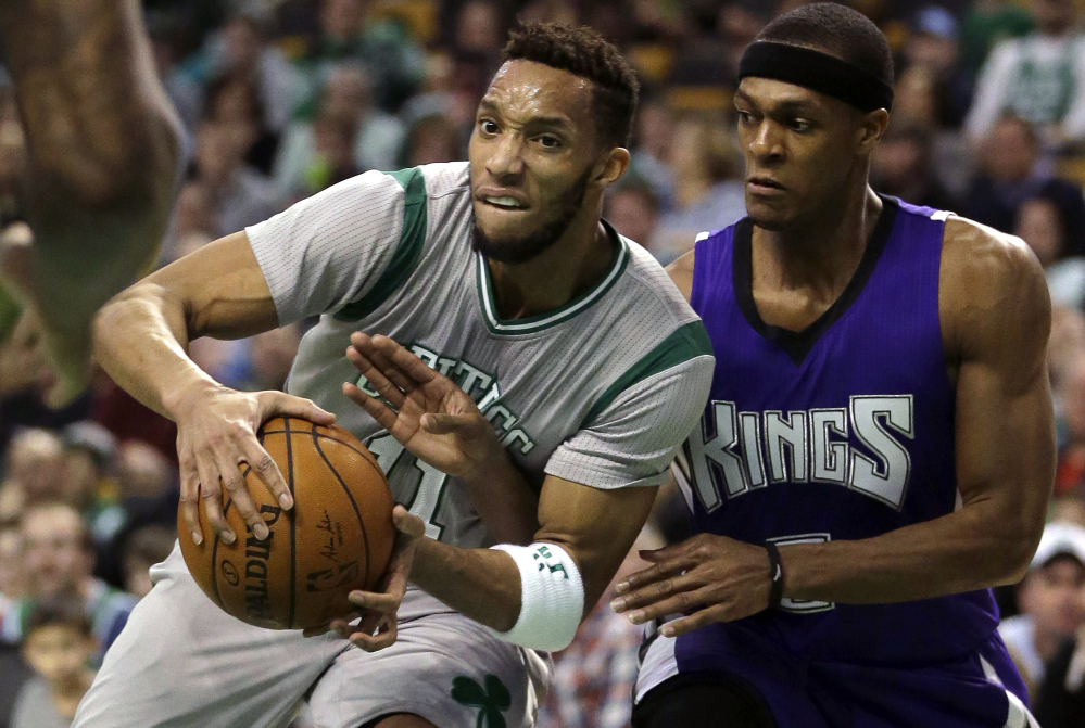 Evan Turner, left, of the Celtics drives against a former Boston teammate, Sacramento point guard Rajon Rondo, during the Celtics’ 128-119 win Sunday afternoon at the TD Garden.