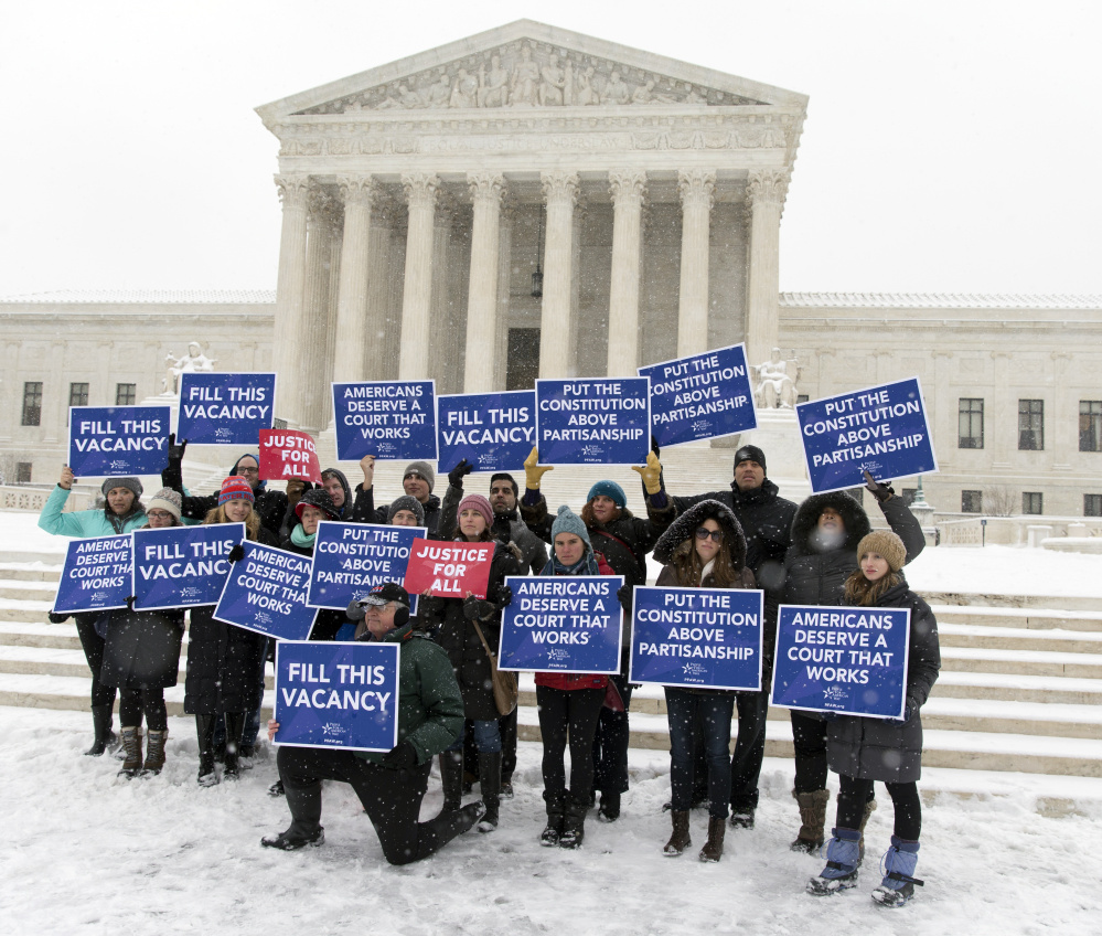 A group with “People for the American Way” from Washington gather with signs in front of the U.S. Supreme Court on Monday as they call for Congress to give fair consideration to any nomination put forth by President Obama to fill the seat of Antonin Scalia.