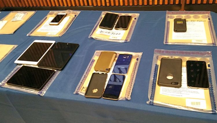 A collection of Apple iPhones and iPads fill a table during a news conference at New York City Police Headquarters, Thursday. Police and prosecutors say that the top-notch encryption technology on Apple mobile phones is now routinely hindering criminal investigations. The Associated Press