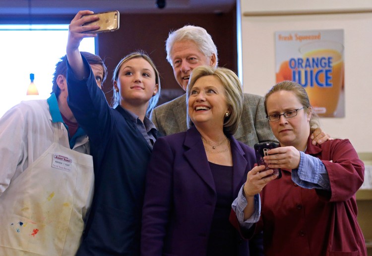 Democratic presidential candidate Hillary Clinton and her husband, former President Bill Clinton, pose for a selfie with employees at Market Basket supermarket on Tuesday in Manchester, N.H. 