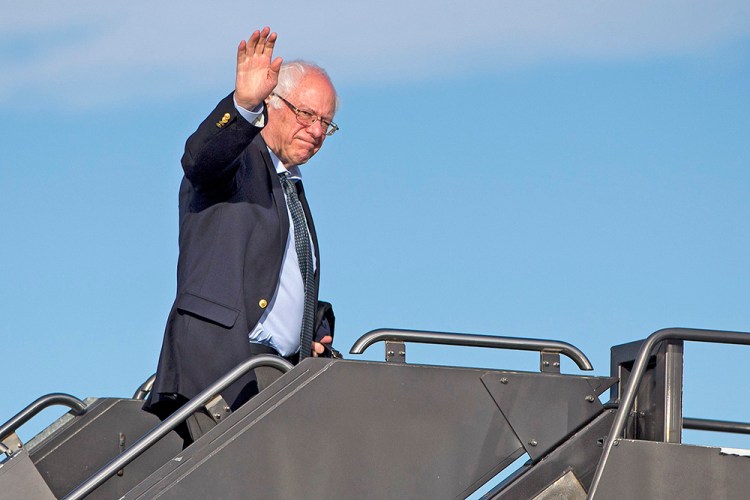 Democratic presidential candidate Sen. Bernie Sanders, I-Vt. waves as he boards his plane in Denver Monday,en route to Minnesota. The Associated Press