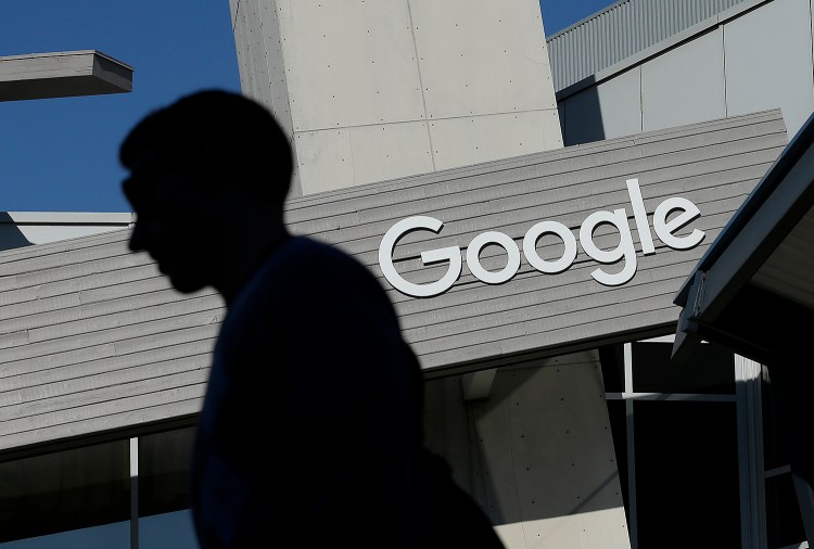 FILE - In this Nov. 12, 2015, file photo, a man walks past a building on the Google campus in Mountain View, Calif. The Associated Oress