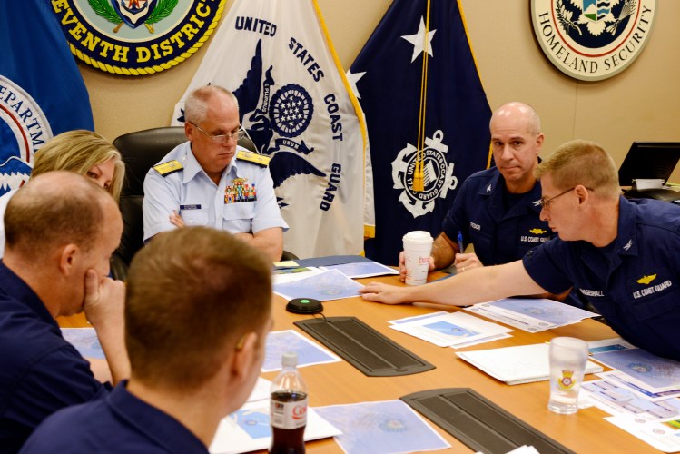 In this Oct. 3, 2015, file photo, Rear Adm. Scott Buschman, commander of the Coast Guard 7th District, receives an update brief for the missing cargo ship El Faro at the Coast Guard 7th District in Miami. A series of U.S. Coast Guard hearings starting Tuesday, Feb. 16, 2016, will seek answers about why the freighter El Faro sank near the Bahamas last fall, killing all crew members in the worst U.S. commercial maritime disaster in decades.