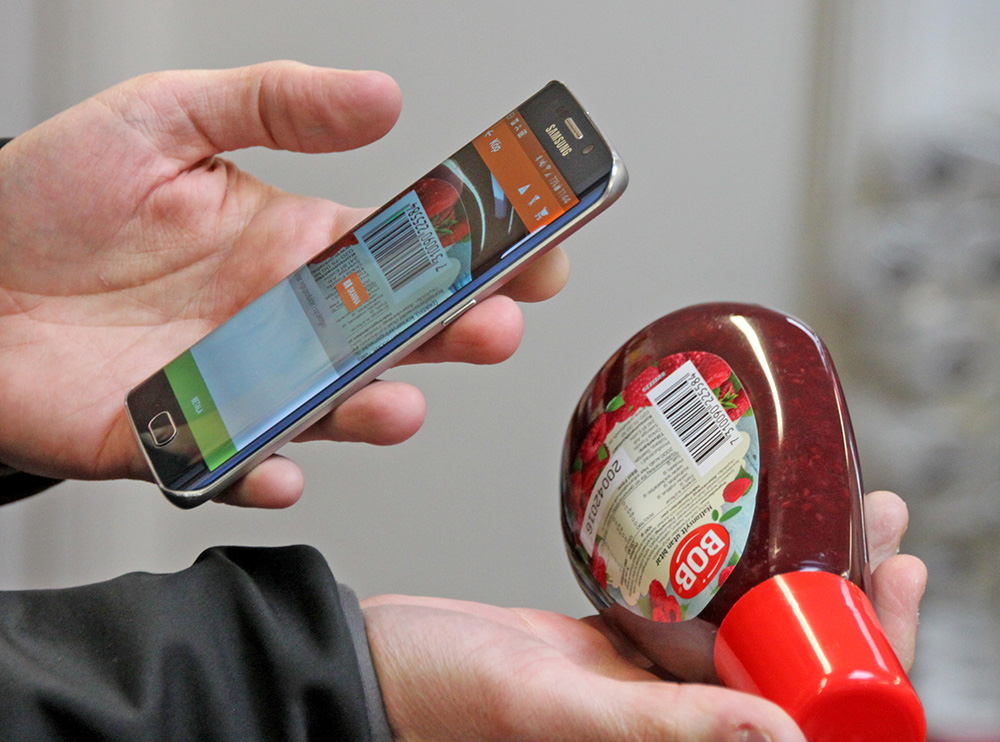 Swedish entrepreneur Robert Ilijason shows how to use a cellphone to scan a purchase at the no-staff shop in the southern Sweden village of Viken. The Associated Press