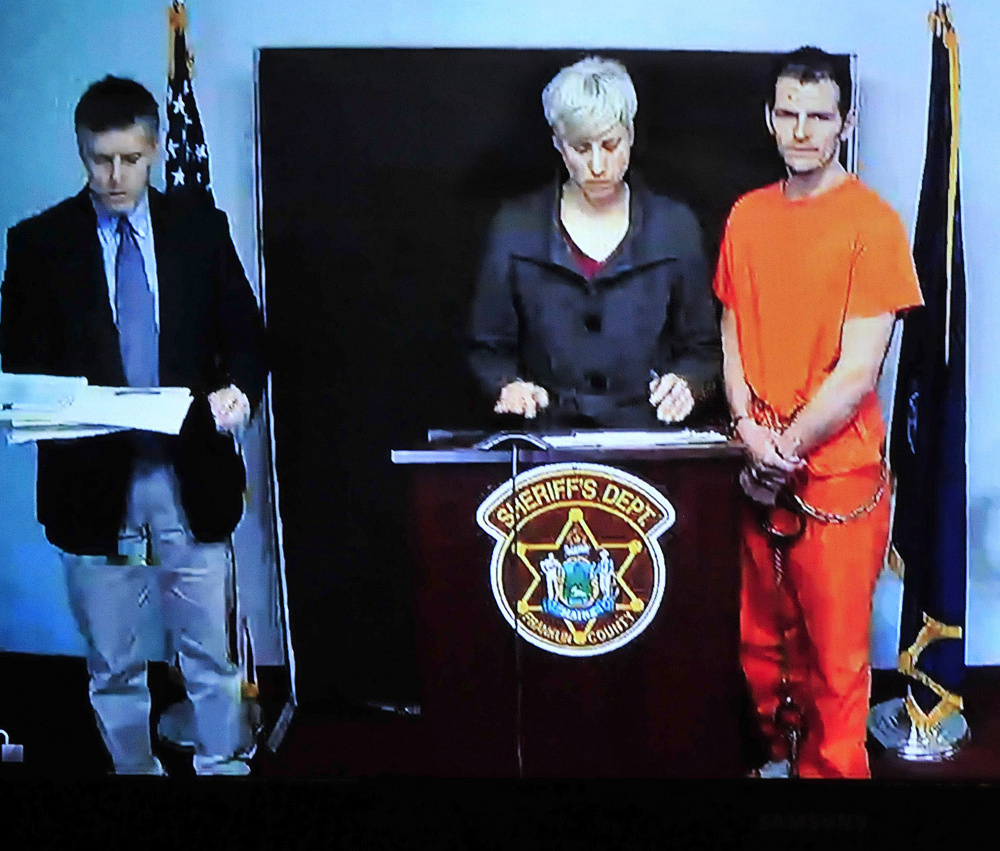 A video screen in Rumford District Court Wednesday shows Derek Cook, his defense attorney Luann Calcagni, and Franklin County Assistant District Attorney Joshua Robbins. Cook was arraigned on seven charges stemming from an escape from a Franklin County Sheriff’s Office transport van in Wilton Tuesday.