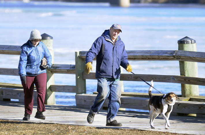 Don and Juliet Morang, of West Gardiner, walk their dog, Jake, along the Kennebec River in Gardiner on Thursday.