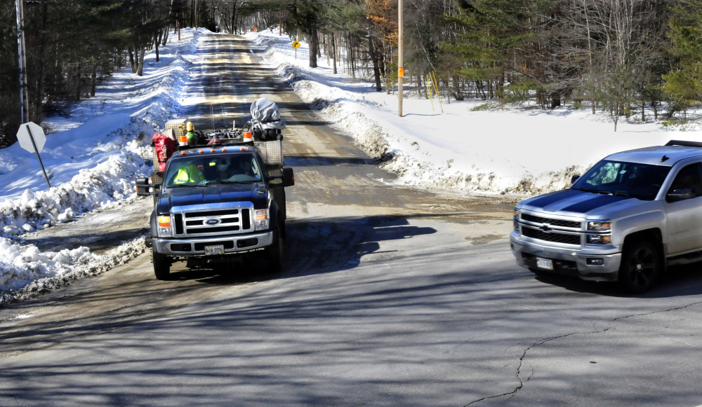 The truck at left stops at the end of the Katie Crotch Road in Embden, which is missing its sign, for another truck passing at the intersection of Route 16 on Thursday. Voters at the Embden town meeting will vote on whether to rename the road to the Cadie Road in hopes of ending the chronic theft of road signs, which costs the town several hundred dollars a year. Town Meeting voters in 2012 rejected a similar proposed change.
