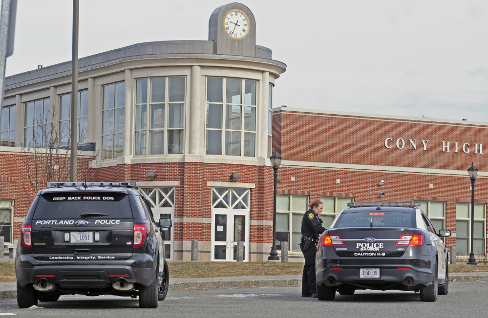 An Augusta police officer talks to a Bangor police officer during the search of school system buildings following a bomb threat that was received on Friday at Cony High School in Augusta.