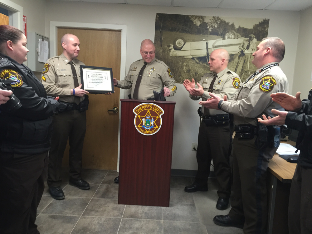 Cpl. Matthew Brann receives the Meritorious Service Award for his part in helping save the life of a truck driver who was shocked by electric wires while delivering grain in New Vineyard in December.