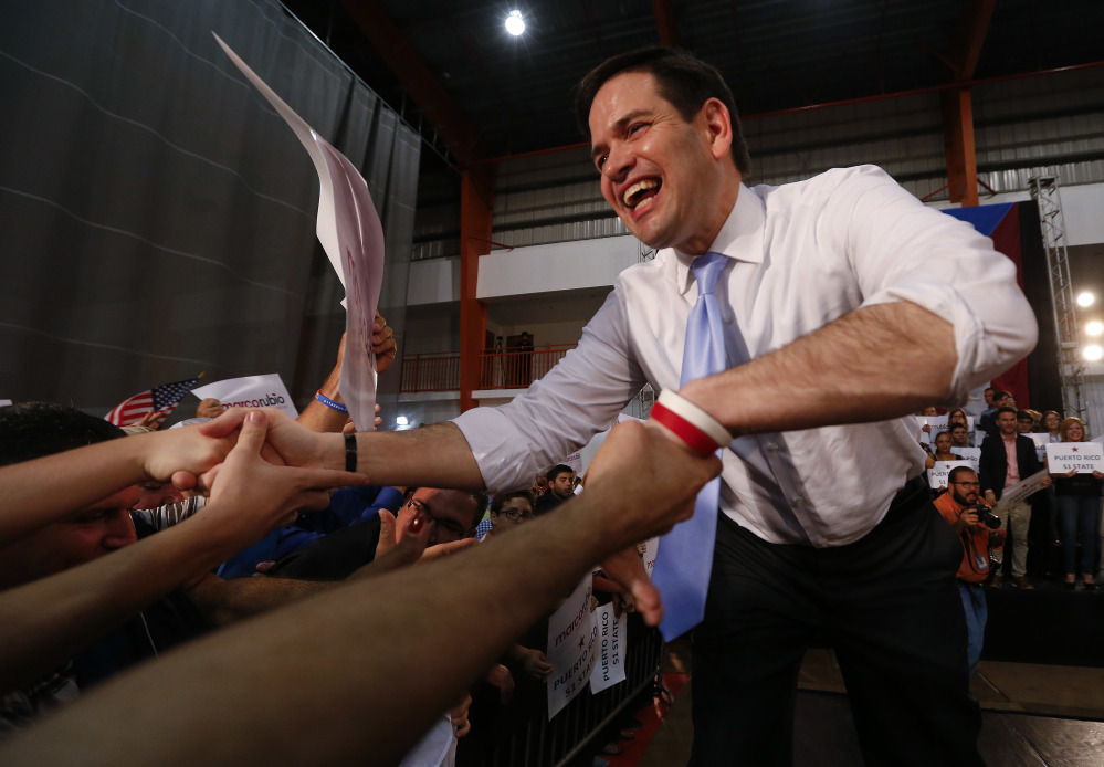 Republican presidential candidate, Sen. Marco Rubio, R-Fla., shakes hands at a rally in Toa Baja, Puerto Rico, Saturday.