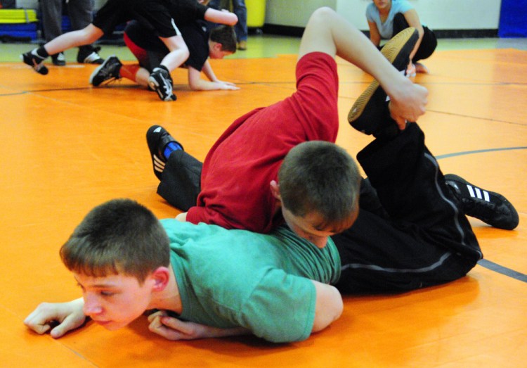 Devyn Purington, left in green, and twin brother Dana Purington do a drill during wrestling practice on Thursday at Gardiner Regional Middle School.