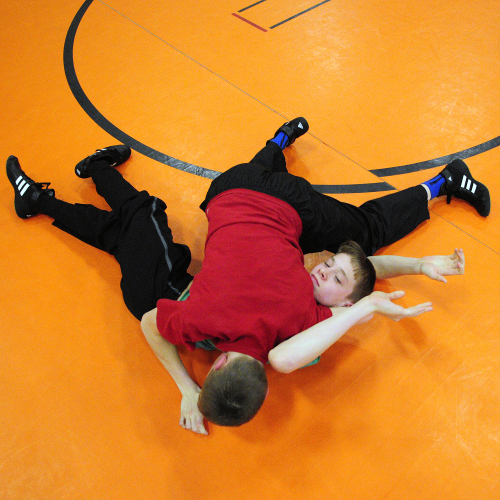 Dana Purington, top in red, and twin brother Devyn Purington do a drill during wrestling practice on Thursday at Gardiner Regional Middle School.