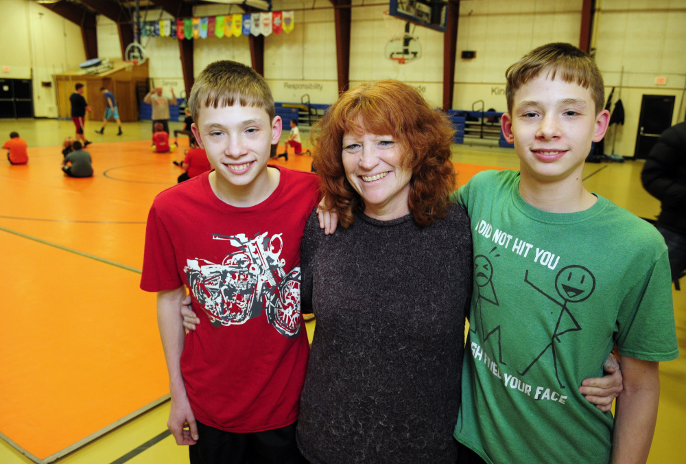 Mud In Your Face organizers Dana Purington, left, Penny McKinney and Devyn Purington pose for a photo during wrestling practice on Thursday at Gardiner Regional Middle School.