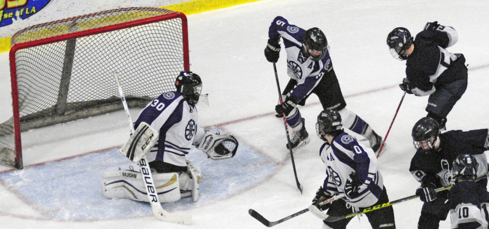 Waterville goalie Nathan Pinnette guards the net with defenseman Andrew Roderigue against Yarmouth during the Class B boys hockey state championship game Saturday at Androscoggin Bank Colisse in Lewiston.