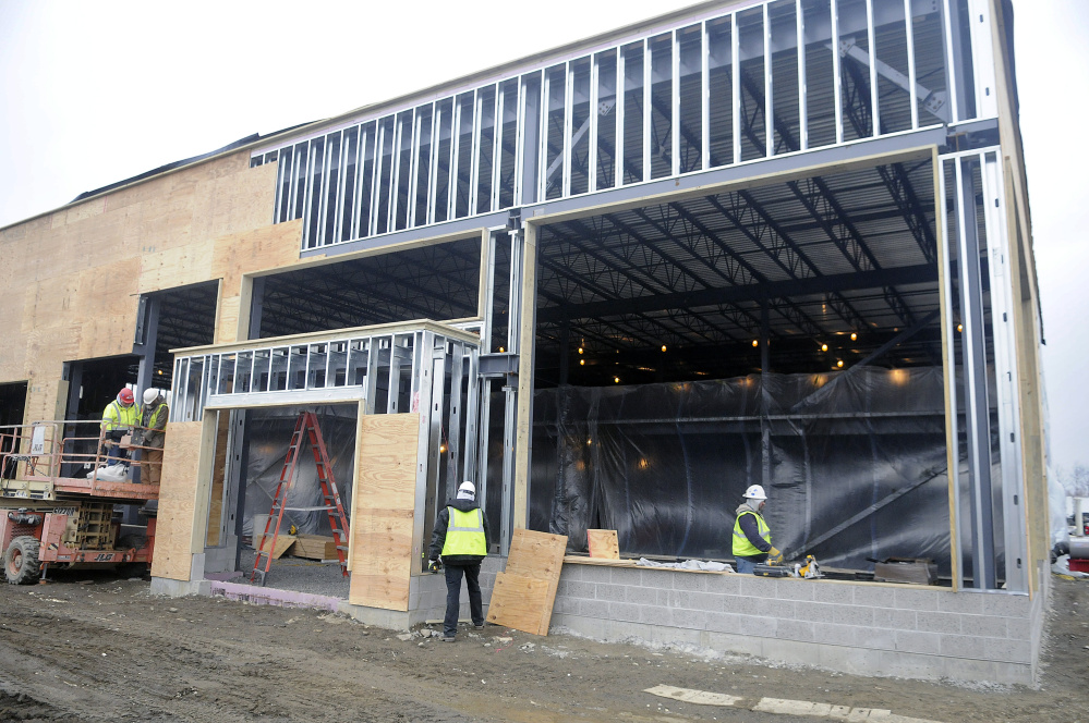 Workers on Monday construct a new building for Darling’s Auto Group at the corner of Old Winthrop Road and Western Avenue in Augusta to take the place of the car dealer’s primary building at 439 Western Ave.