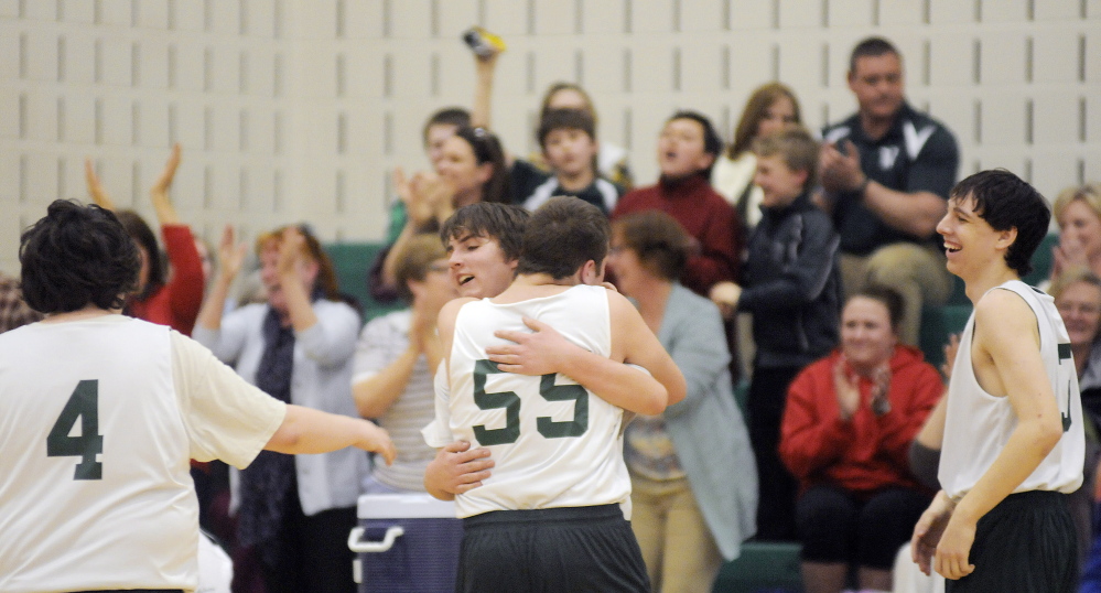 Sebastian Coston, right, hugs Winthrop unified teammate Sage Thomas after Thomas drained a 3-pointer that drove fans and teammates to their feet during a quarterfinal game against Messalonskee last season in Winthrop.
