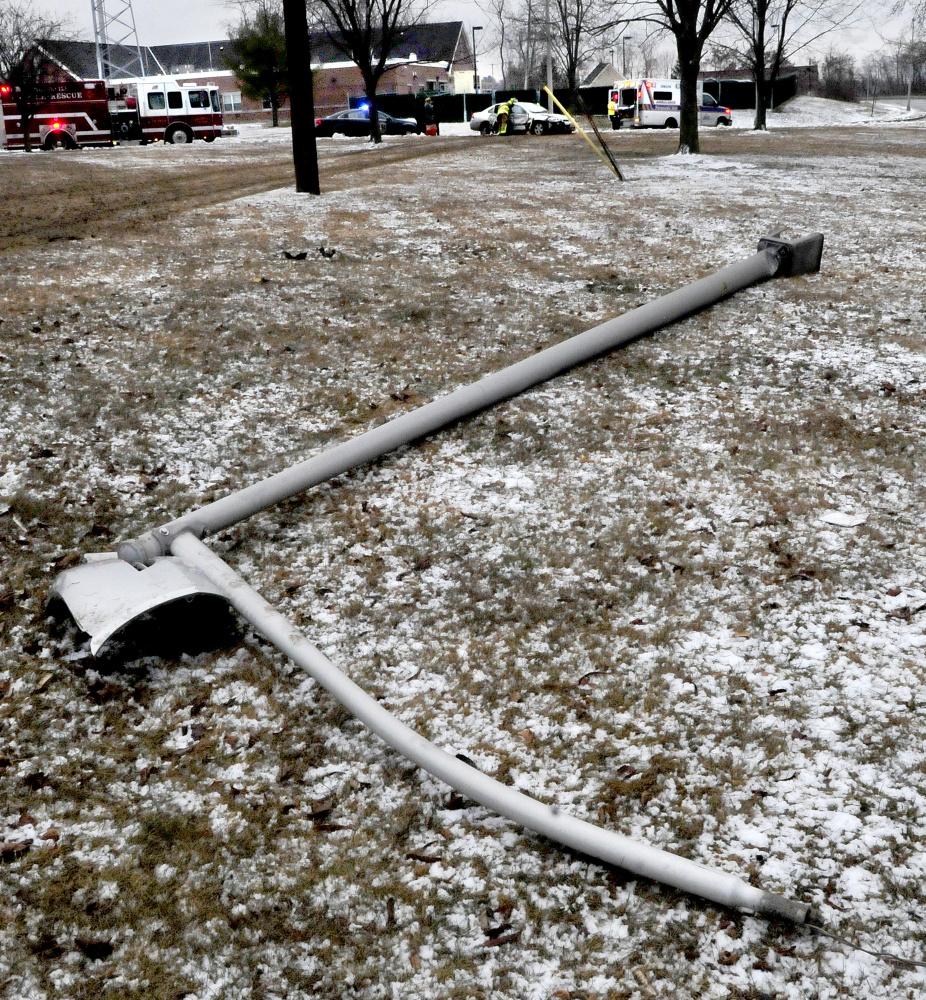 One of two light poles were knocked down by an out of control vehicle that slid off Front Street in Waterville on Monday.