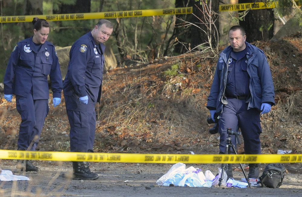State Police detectives and evidence technicians examine where two bodies were discovered in an SUV on Sanford Road in Manchester early Christmas morning.