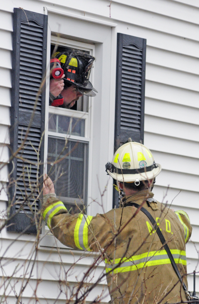 Augusta firefighters confer as several departments work at the scene of a house fire on Thursday at 65 Second St. in Hallowell.