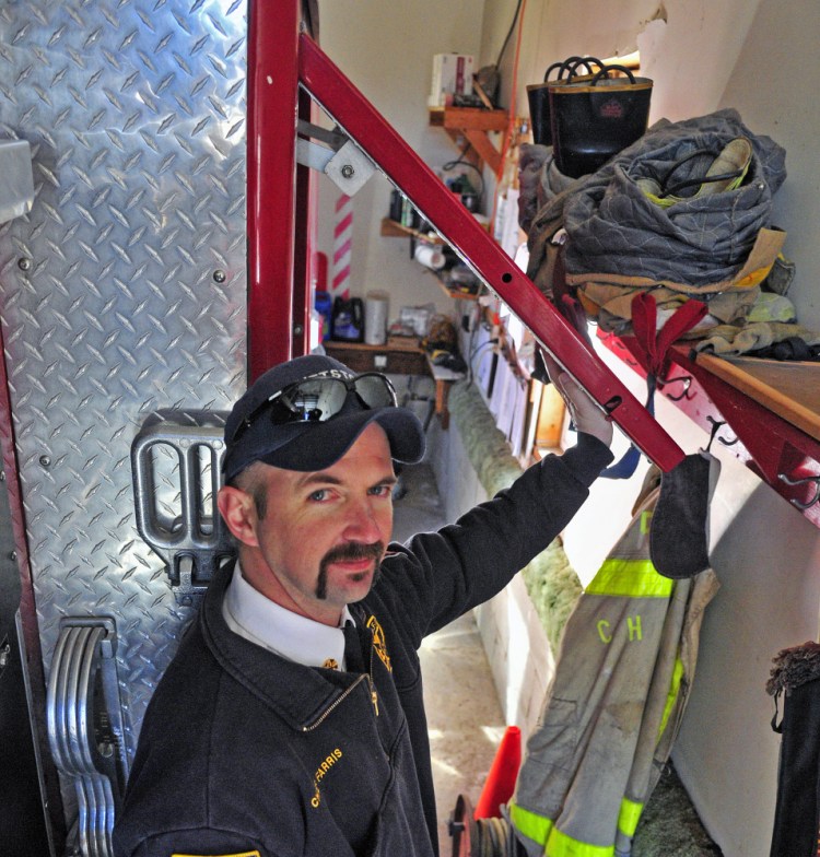 Pittston Fire Chief Jason Farris demonstrates on Saturday that the storage compartment doors on fire engines can’t be opened inside the tight confines of the fire station in East Pittston village.