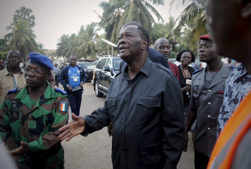 Ivory Coast President Alassane Ouattara, center, arrives at the hotel Etoile du Sud in Grand-Bassam a few hours after gunmen terrorized beachgoers on Sunday,