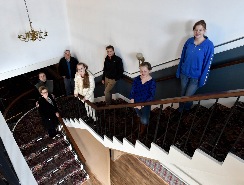 Seen inside The Country Manor on college Avenue in Waterville are, from left: Erika and JR Russell, Dan Savage, and the Russell children — Josie, 11, Max, 16, Dovelyn, 9, and Ashley, 21. The Russells are working to transform the former John Martin’s Manor into a steakhouse, banquet facility, full-service bridal business, children’s boutique and consignment shop for high-end furniture, clothing, jewelry and other items.