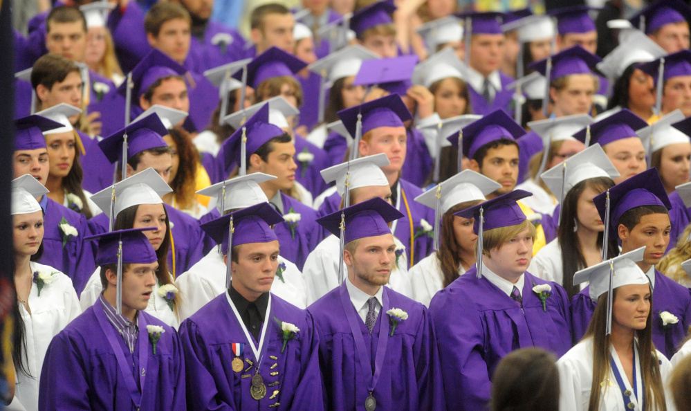 Waterville Senior High School’s class of 2014 sports purple gowns for boys and white for girls. This year’s seniors voted Thursday to do away with gender-specific colors and everyone will wear purple.