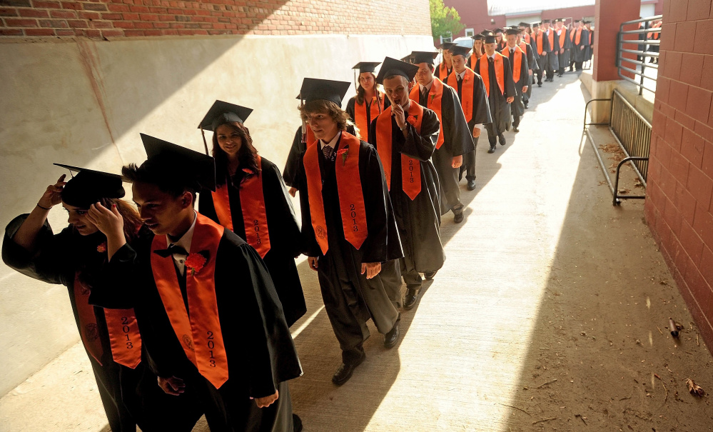 The Winslow High School graduating class waits outside Wadsworth Gymnasium at Colby College in Waterville before commencement ceremonies in 2013. The school has the same color graduation gowns for both genders and has for some time. Waterville High School seniors voted this year to have one color gown.