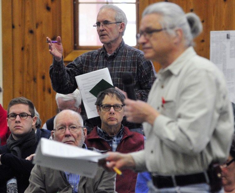 Phil Sprague, left, and Tom Streznewski discuss a warrant item Saturday during Belgrade’s Town Meeting in the Center For All Seasons.