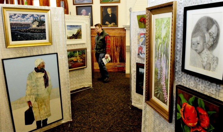 Sculptor Mark Berlinger of Belgrade Lakes looks over the artwork at the Maine Open Juried Art Show on exhibit at the Waterville Public Library on Sunday.