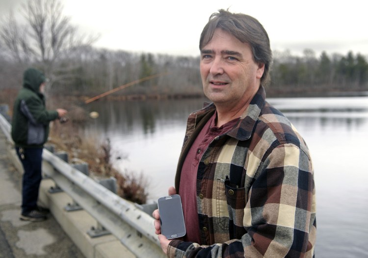 West Gardiner resident Ron Cote, shown here last week at Togus Pond in Augusta, has developed an app for smartphones to help fishermen make sense of the state’s rule book on fishing. Because it downloads a database to the phone, no cell service is needed to access the information.