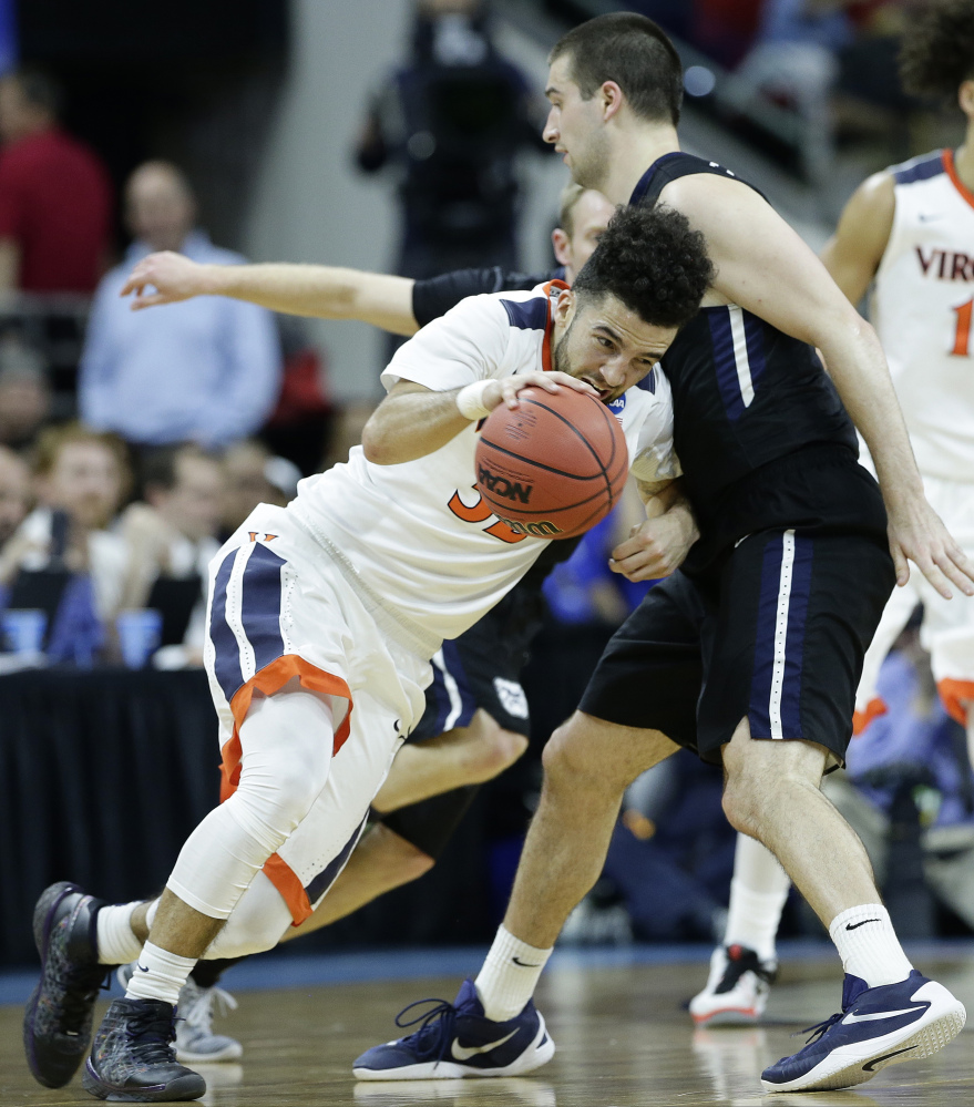 Virginia guard London Perrantes, left, moves past Butler forward Andrew Chrabascz during the first half of an NCAA tournament second round game Saturday in Raleigh, North Carolina.