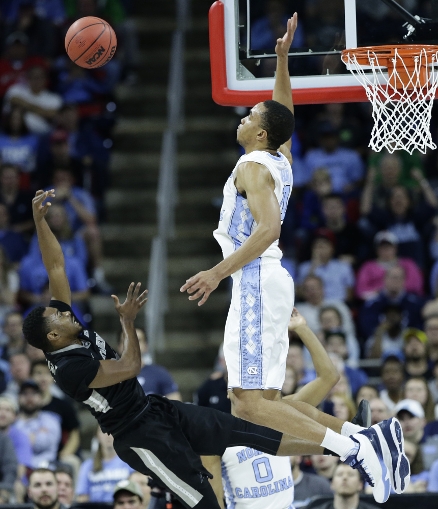 Providence guard Kyron Cartwright shoots as North Carolina forward Brice Johnson prepares to make the block during the first half of an NCAA tournament second round game Saturday in Raleigh, North Carolina.