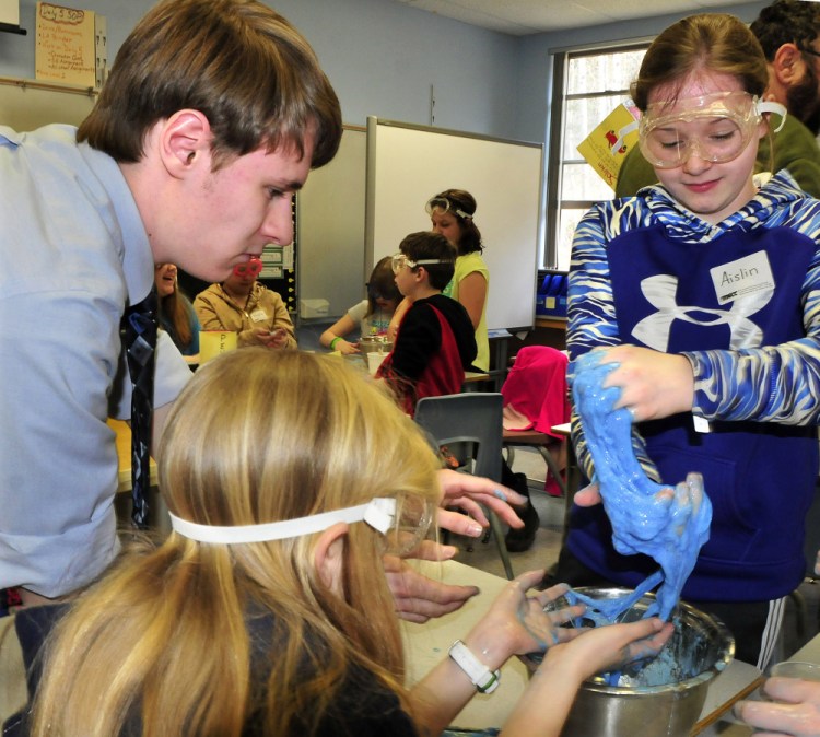Cascade Brook School student Aislin Reynolds works with a gooey substance created by students under the direction of University of Maine in Farmington student Jacob Vining during a science project on Thursday.