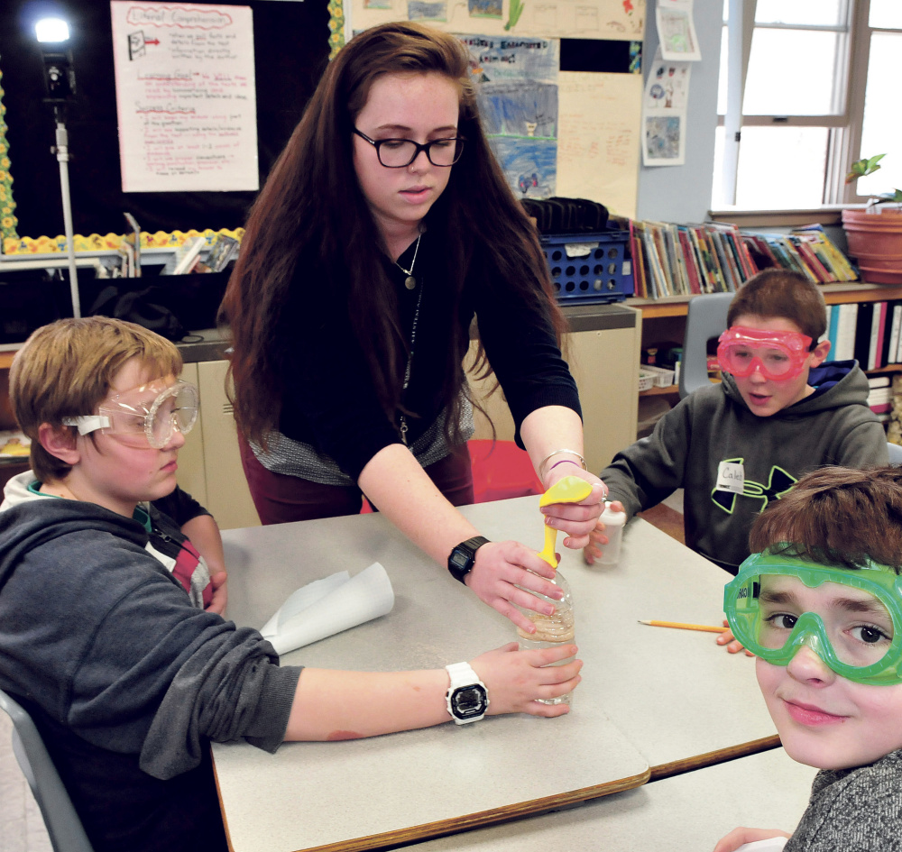 University of Maine in Farmington student Emily Gray works with Cascade Brook School students from left Jacob White, Caleb Norton and Marvin Gray on a science project on Thursday.