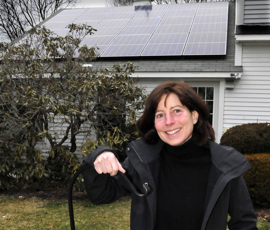Jan King stands outside her home in Waterville on Thursday, where solar panels were recently installed on the roof as part of the Solarize Mid-Maine project.