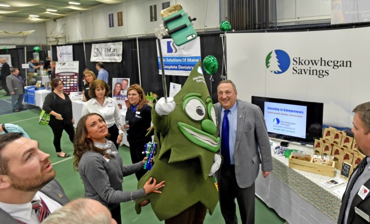 Gov. Paul LePage, right center, has a selfie taken Thursday with Trusty, the Skowhegan Savings Bank mascot, and Fawn Wentworth, left center, at the 2016 Business-to-Business Showcase at Colby College in Waterville.