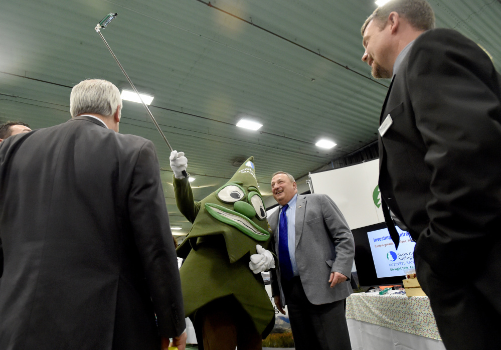 Gov. Paul LePage, right center, has a selfie taken Thursday with Trusty, the Skowhegan Savings Bank mascot, at the 2016 Business-to-Business Showcase at Colby College in Waterville.