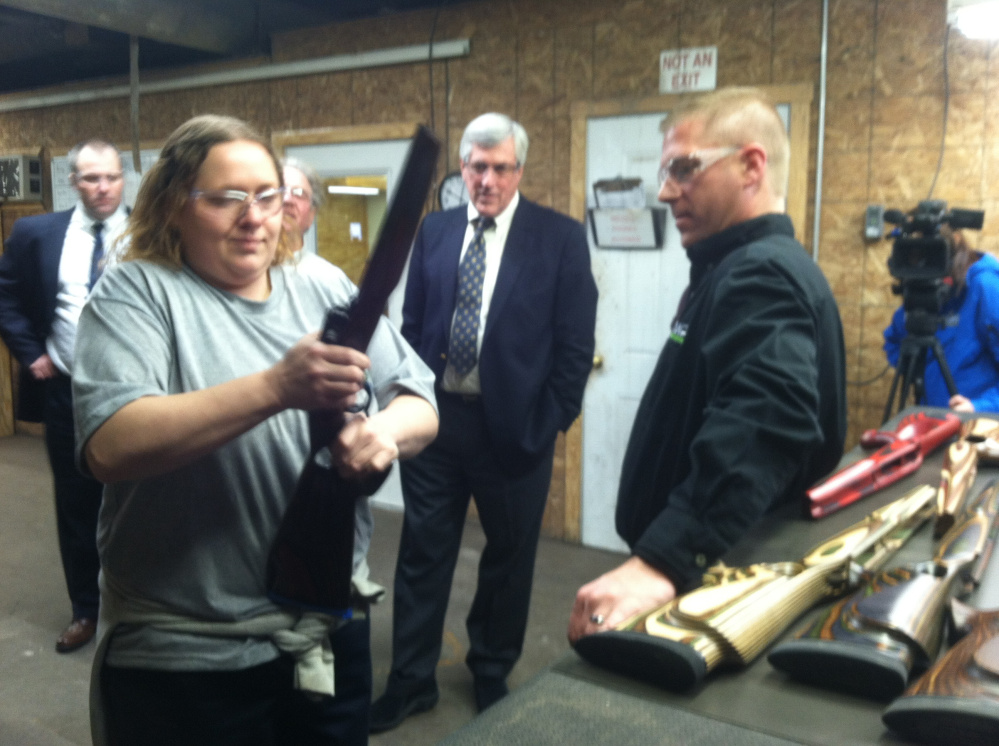 Alicia Lambert fits a rifle barrel into a wooden stock while Brody Cousineau, vice president of Cousineau Wood Products, looks on during a tour of the company’s North Anson factory Friday.
