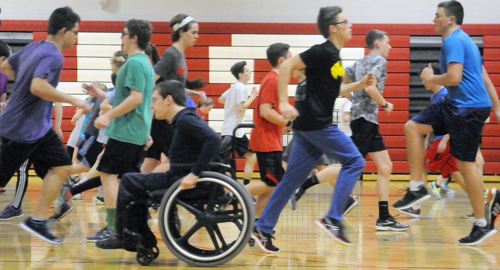 Cony High School track and field athletes stretch during the first day practice Monday at the Augusta school.