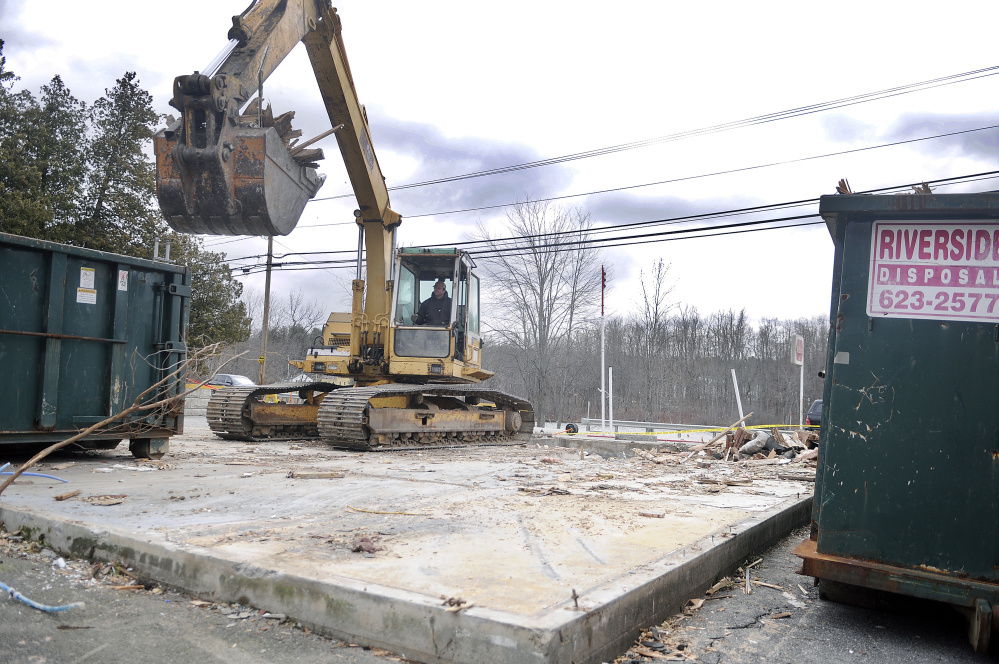 Wes McNaughton excavates the remnants of the New Mills Market in Gardiner on Tuesday for Riverside Disposal. The firm was hired by the building’s new owner to raze the structure.