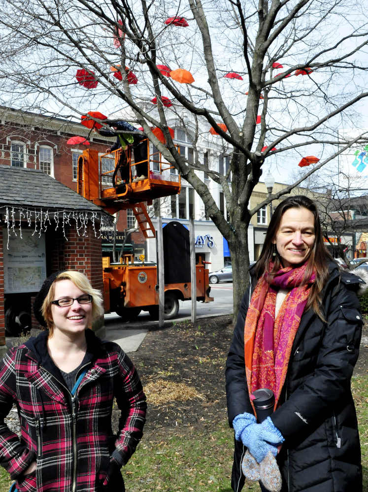 Tamsen Brooke Warner, left, of the Waterville Opera House, and KiKA Nigals, of Waterville Creates!, speak on Wednesday about the the installation of dozens of umbrellas in a tree in downtown Waterville. The umbrellas are part of a celebration of the visual and performing arts in the city.