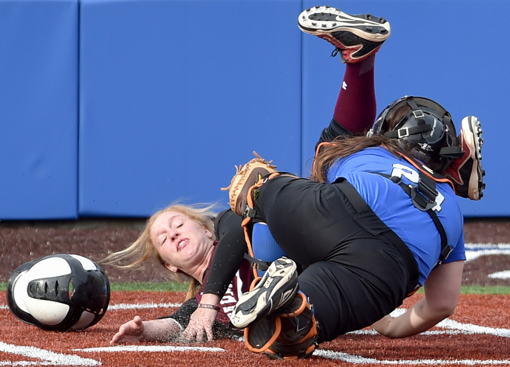 Colby College catcher Skylar Labbe, front, tags out University of Maine at Farmington runner Ashley Gleason at home plate during a non-conference game Wednesday in Waterville. The Mules swept a doubleheader in the first games on their new field.